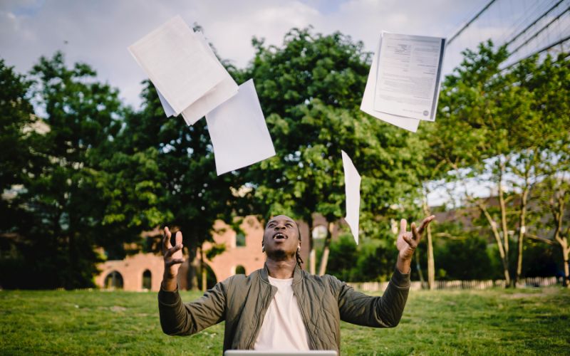 Person throwing resumes with courses added to the air