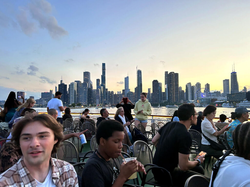 Mission St. Louis students eating outdoors with Lake Michigan and the Chicago skyline in the background